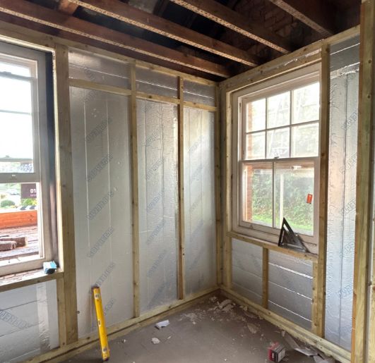 Insulated external walls with service battens around two sash windows